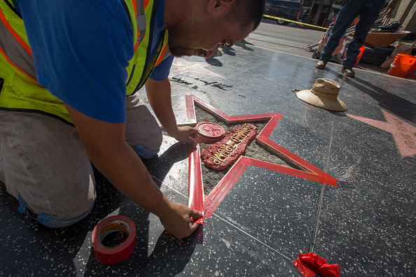 HOLLYWOOD, CA - OCTOBER 26: Workers repair the Hollywood Walk of Fame star of Republican presidential candidate Donald Trump after it was vandalized by a protester on October 26, 2016 in Hollywood, California. James Lambert Otis claims to have originally intended to remove the entire star to auction it off and give the money to about a dozen women who allege that Trump groped or sexually mistreated them. Dressed as a construction worker and using a hammer and pick, Otis was only able to break up part of the star. (Photo by David McNew/Getty Images)